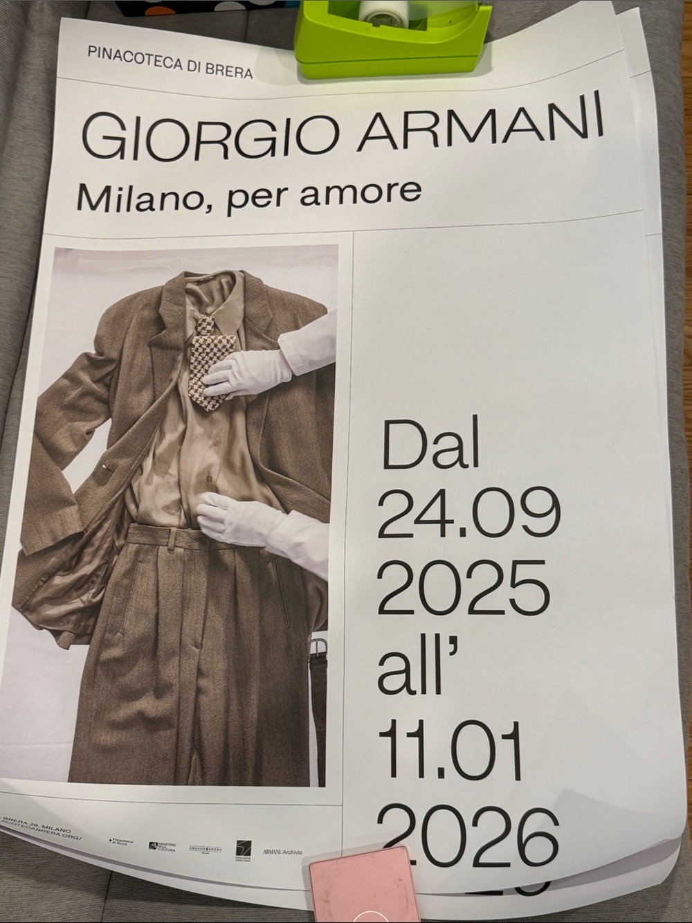 Giorgio Armani sepia suit poster with white text